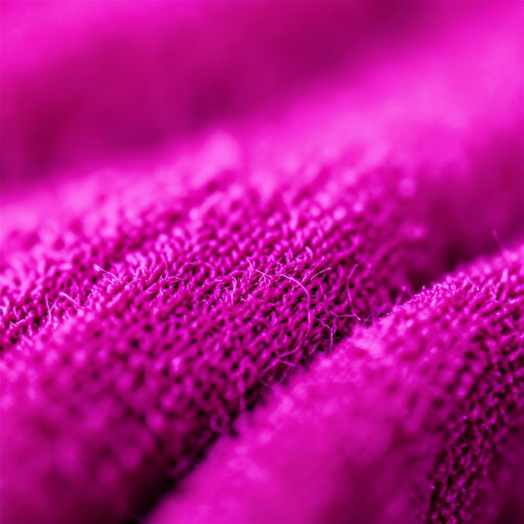 Macro shot of a keyboard with shallow depth of field, lit in warm pinks and soft yellow.